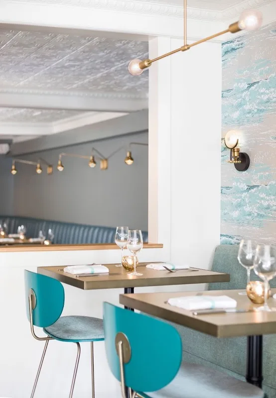 or, The Whale interior — teal chairs, ocean wave wallpaper